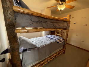 Bedroom with baseboards, carpet, a ceiling fan, and a textured ceiling