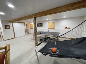 Recreation room featuring light carpet, recessed lighting, a textured ceiling, and baseboards