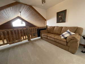 Unfurnished living room with carpet floors, ceiling fan, and vaulted ceiling