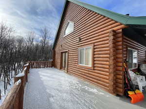 View of property exterior with log siding and a deck
