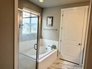 Bathroom featuring a stall shower and a garden tub