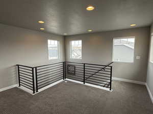 Carpeted spare room with recessed lighting, a textured ceiling, and baseboards