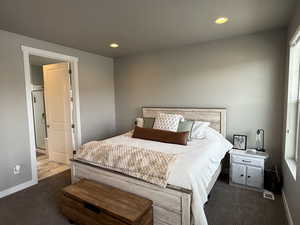 Bedroom with recessed lighting, dark carpet, and baseboards