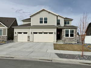 Craftsman house featuring a shingled roof, fence, concrete driveway, a garage, and stone siding