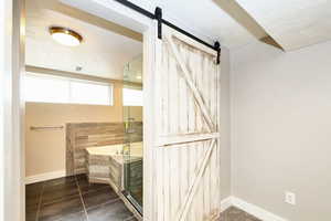 Bathroom with baseboards, a shower stall, a textured ceiling, tile patterned floors, and a bath