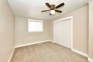 Unfurnished bedroom featuring baseboards, a textured ceiling, and carpet flooring