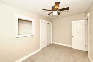 Unfurnished bedroom with baseboards, carpet floors, and a textured ceiling