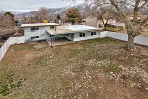 Back of property featuring a patio, a fenced backyard, a mountain view, an attached carport, and central AC unit