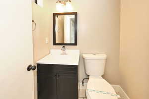 Bathroom with vanity, toilet, and baseboards