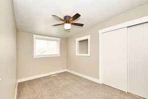 Unfurnished bedroom with visible vents, baseboards, carpet flooring, a closet, and a textured ceiling