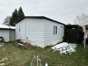 View of property exterior with cooling unit and a lawn