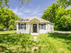 Bungalow-style house with a front lawn and a shingled roof