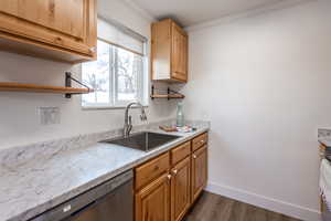 Kitchen with ornamental molding, a sink, open shelves, baseboards, and dishwasher