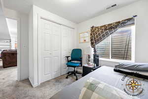 bedroom 7 featuring a closet, visible vents, a textured ceiling, and baseboards