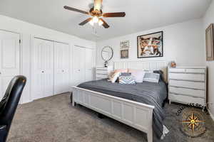 Primary Bedroom featuring carpet flooring, ceiling fan, and multiple closets