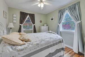 Bedroom #2 with wood finished floors, ceiling fan, and baseboards