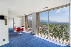 Interior space with carpet, a chandelier, a mountain view, and expansive windows
