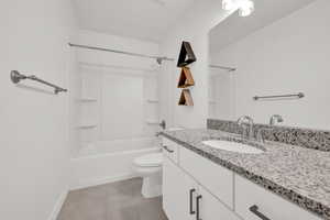 Bathroom with tile patterned flooring, baseboards, toilet, shower / tub combination, and vanity