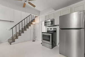 Kitchen with stainless steel appliances, ceiling fan, and light tile patterned floors
