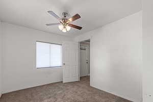 Main floor bedroom featuring carpet flooring and a ceiling fan