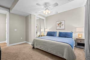 Carpeted bedroom featuring a closet, a ceiling fan, and baseboards