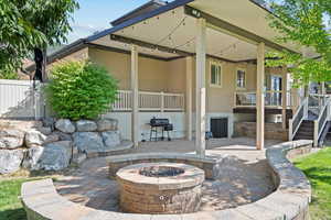 View of patio with stairway, fence, a grill, and an outdoor fire pit