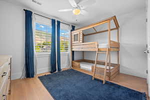 Bedroom featuring visible vents, baseboards, and wood finished floors