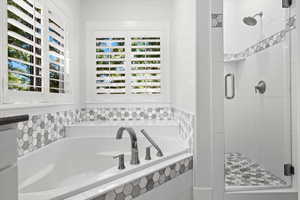 Bathroom featuring a shower stall and a bath