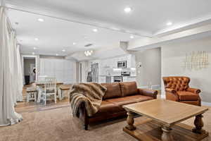 Living area featuring visible vents, crown molding, recessed lighting, and baseboards