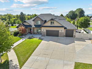 Craftsman house featuring a gate, fence, stucco siding, a front lawn, and concrete driveway