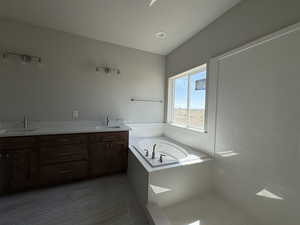 Full bath featuring a bath, a sink, and double vanity