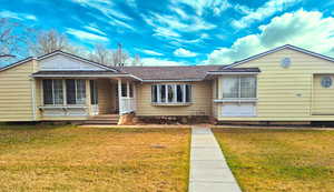 Single story home with a front lawn, roof with shingles, crawl space, and a porch