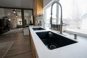 Kitchen featuring ceiling fan, a healthy amount of sunlight, dark wood-style flooring, and a sink