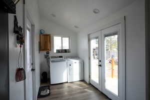 Laundry area with light wood-style flooring, french doors, and independent washer and dryer
