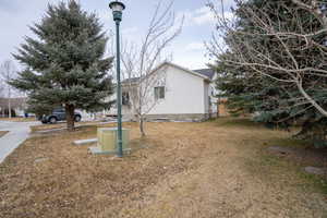 View of side of home with a yard