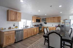 Kitchen featuring recessed lighting, light wood-style flooring, stainless steel appliances, and a sink