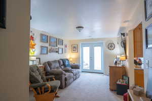 Living room featuring french doors and light carpet