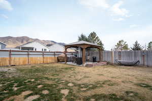 View of yard with a gazebo, a fenced backyard, a mountain view, and a patio