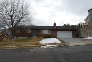 Single story home featuring fence, an attached garage, a chimney, concrete driveway, and brick siding