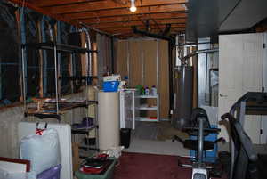 Unfinished below grade area featuring gas water heater and separate washer and dryer