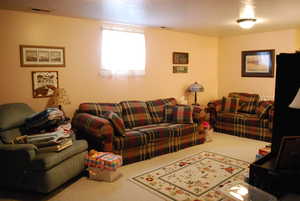 Living area with carpet flooring and visible vents