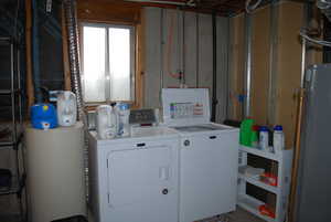 Laundry room with laundry area, washing machine and dryer, and water heater