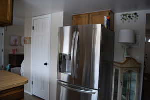 Kitchen featuring brown cabinetry, stainless steel fridge, and light countertops