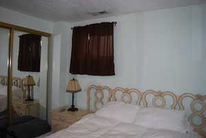 Bedroom featuring visible vents and a textured ceiling