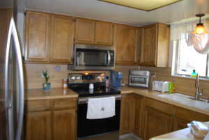 Kitchen featuring appliances with stainless steel finishes, brown cabinets, light countertops, and a sink