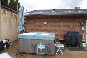 View of patio with a grill and a hot tub