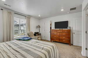 Bedroom featuring recessed lighting, light colored carpet, and visible vents