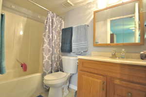 Bathroom with visible vents, toilet, vanity, and shower / bath combination.