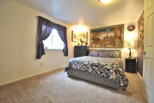 Carpeted bedroom featuring baseboards. This is adjacent to the basement family room.