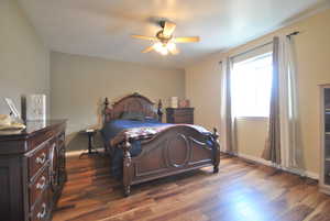 Main Bedroom with wood-style floors, ceiling fan, and baseboards.  This room features an attached bathroom and walk in closet.